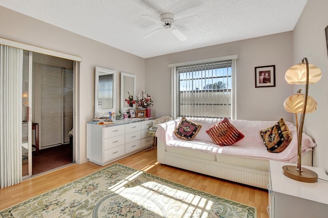 interior space featuring ceiling fan, a textured ceiling, and light hardwood / wood-style flooring