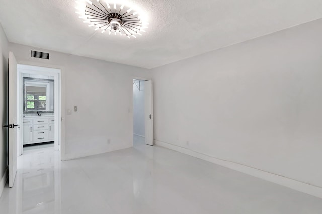 unfurnished room with a textured ceiling