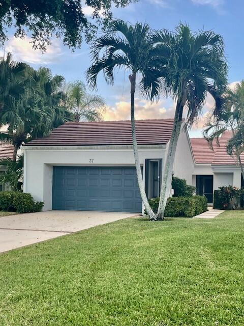 single story home with a garage and a yard