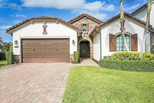 mediterranean / spanish home with a garage and a front lawn