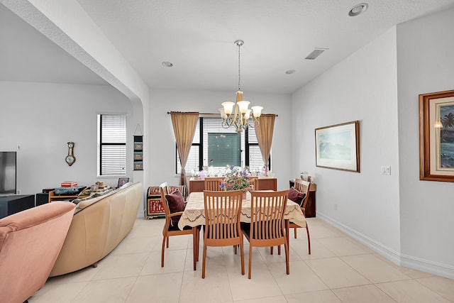 dining space with light tile patterned floors and an inviting chandelier