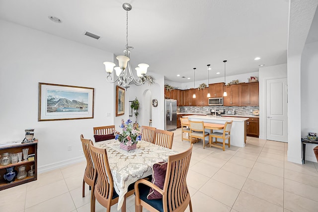 tiled dining area with a chandelier