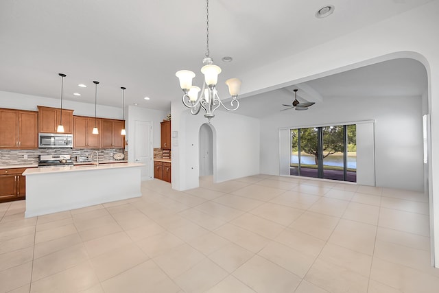 kitchen featuring decorative backsplash, lofted ceiling with beams, hanging light fixtures, and stainless steel appliances