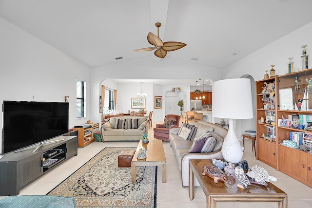 tiled living room featuring ceiling fan with notable chandelier and lofted ceiling