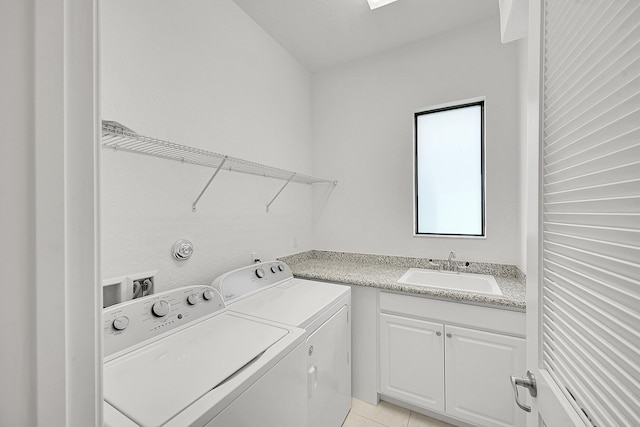 washroom with sink, light tile patterned floors, cabinets, and independent washer and dryer