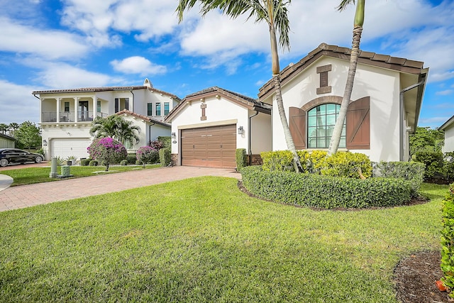 mediterranean / spanish home with a garage, a balcony, and a front lawn