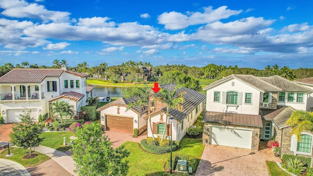 mediterranean / spanish-style home featuring a water view, a garage, and a front lawn