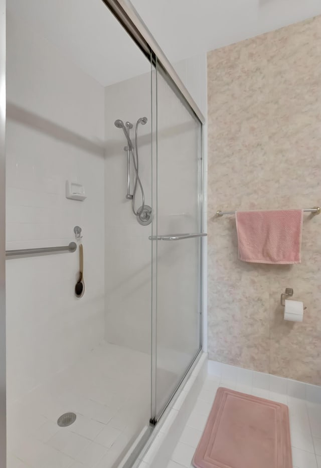 bathroom with tile patterned floors and a shower with door