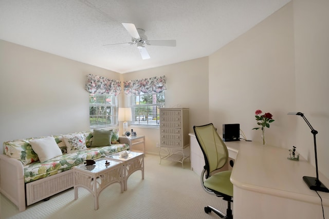 home office with carpet flooring, ceiling fan, and a textured ceiling