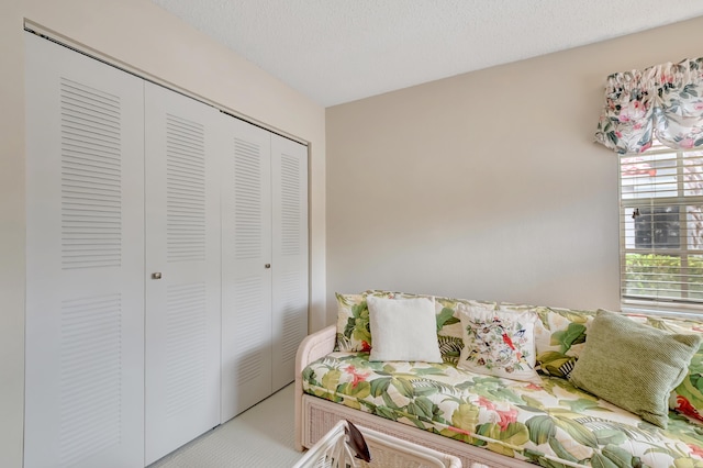 bedroom featuring a closet, carpet floors, and a textured ceiling