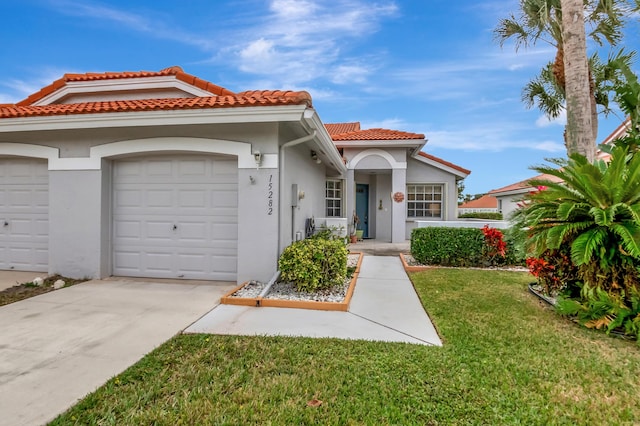 mediterranean / spanish-style house with a front yard and a garage