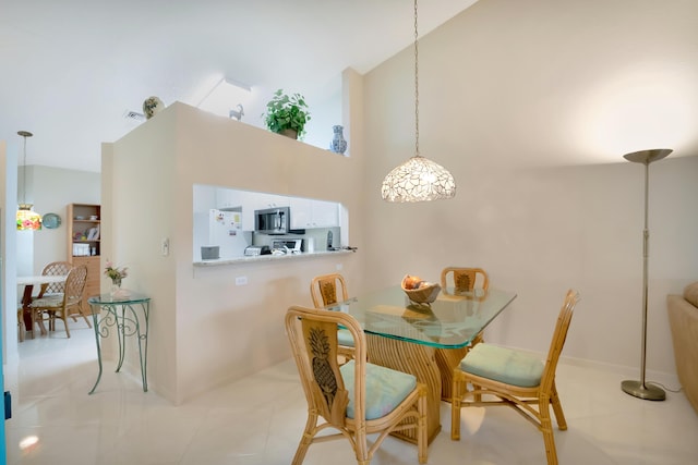 tiled dining area with a high ceiling