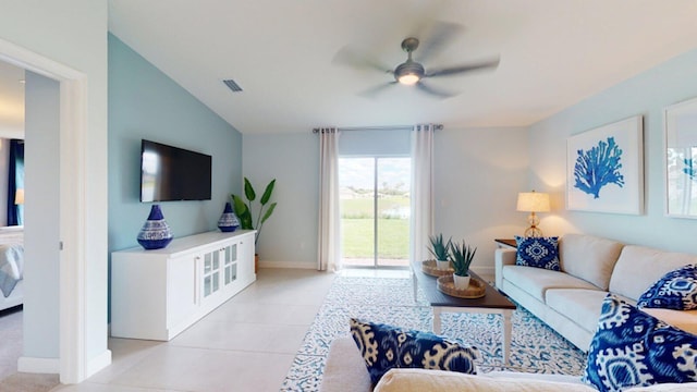 living room featuring ceiling fan, light tile patterned floors, and vaulted ceiling