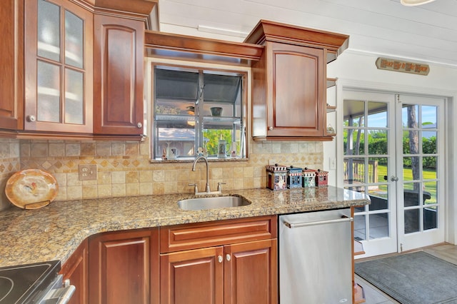 kitchen with tasteful backsplash, light stone counters, sink, and french doors