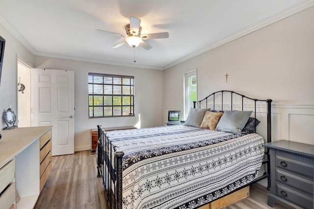 bedroom featuring ceiling fan, ornamental molding, and light wood-type flooring