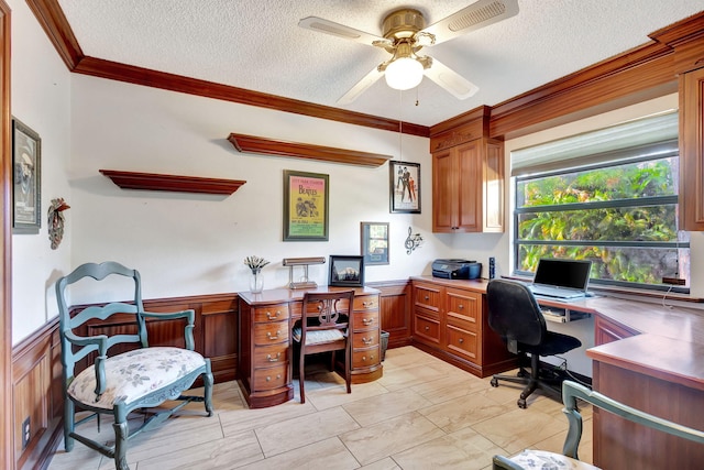 home office with ceiling fan, crown molding, and a textured ceiling