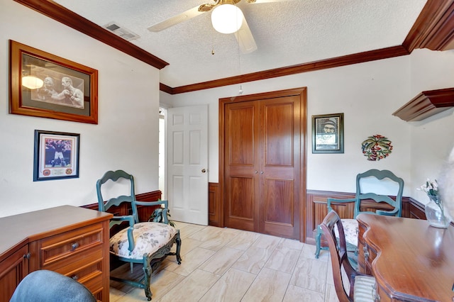 bedroom featuring ceiling fan, crown molding, a textured ceiling, and wooden walls