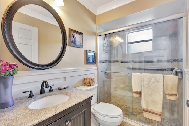 bathroom featuring crown molding, a shower with door, vanity, and toilet