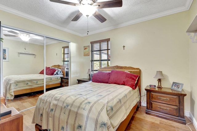 bedroom with ceiling fan, light hardwood / wood-style flooring, a textured ceiling, a closet, and ornamental molding