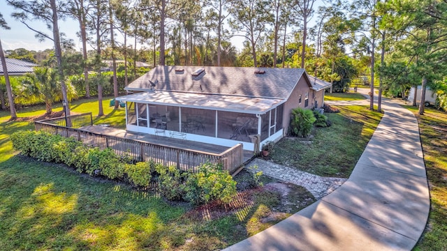 exterior space with a sunroom and a lawn