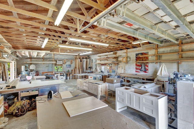 miscellaneous room featuring concrete flooring and a workshop area