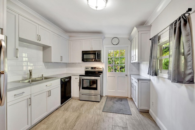 kitchen featuring appliances with stainless steel finishes, backsplash, crown molding, sink, and white cabinetry