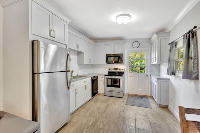 kitchen with white cabinets, sink, backsplash, and appliances with stainless steel finishes