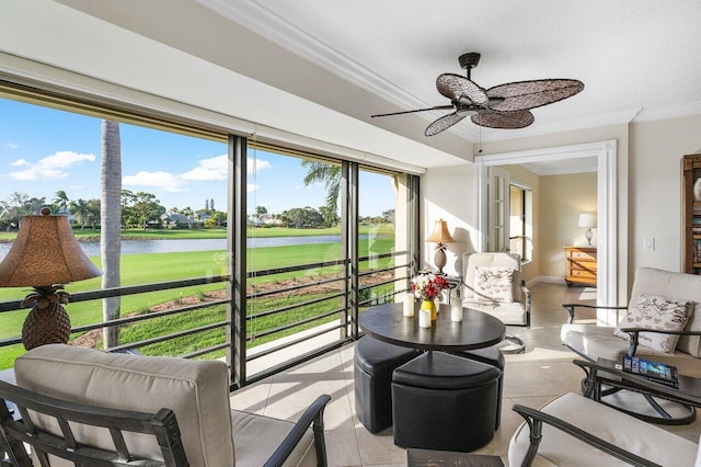 sunroom with ceiling fan and a water view