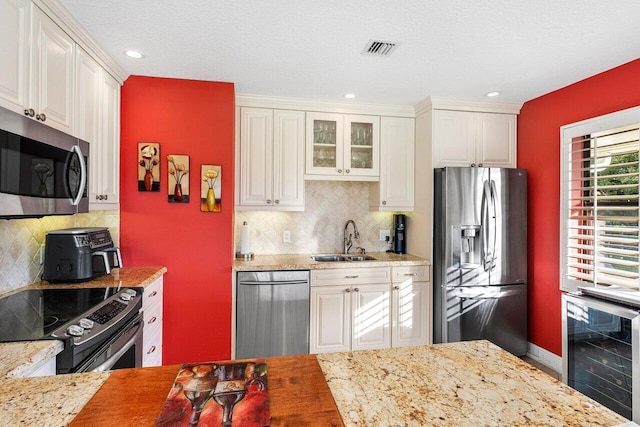 kitchen featuring white cabinetry, sink, beverage cooler, stainless steel appliances, and backsplash