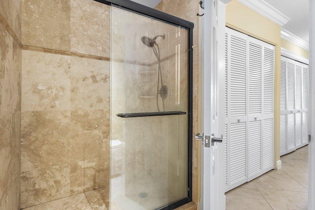 bathroom with tile patterned flooring, walk in shower, and ornamental molding