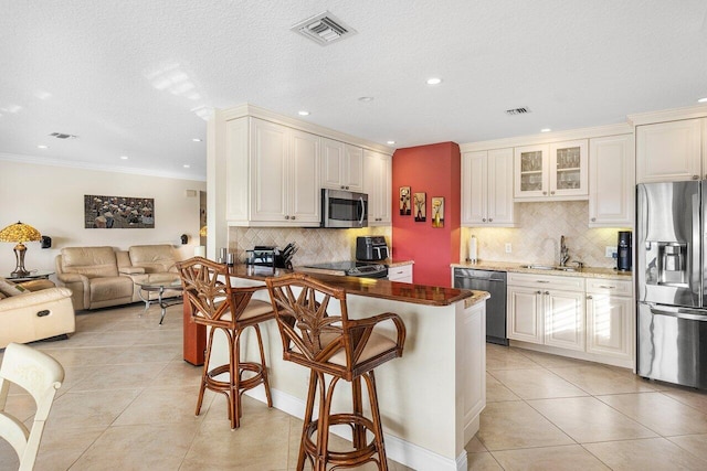 kitchen with sink, stainless steel appliances, a breakfast bar area, and tasteful backsplash