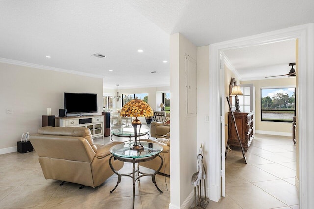 tiled living room featuring a textured ceiling, ceiling fan, and ornamental molding