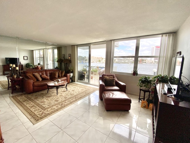 living room with light tile patterned floors, a textured ceiling, and expansive windows