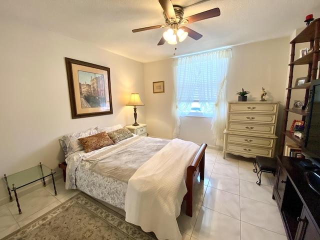 tiled bedroom featuring ceiling fan and a textured ceiling