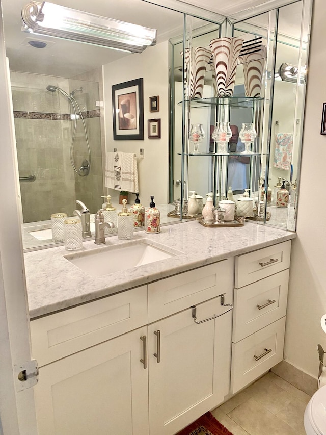 bathroom featuring a tile shower, tile patterned floors, vanity, and toilet