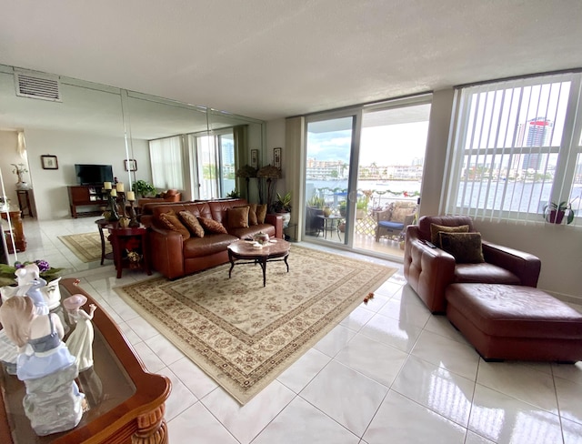 living room with light tile patterned flooring and a wall of windows