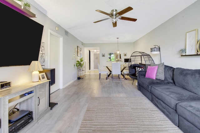 living room featuring ceiling fan and light wood-type flooring