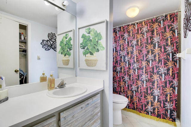 bathroom with tile patterned flooring, vanity, and toilet