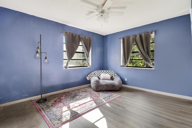 unfurnished room featuring a textured ceiling, hardwood / wood-style flooring, ceiling fan, and a healthy amount of sunlight