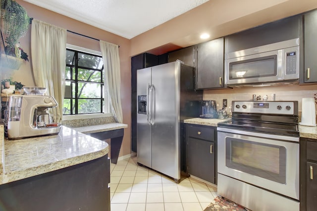 kitchen with light tile patterned floors and stainless steel appliances