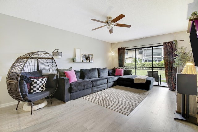 living room featuring ceiling fan and light hardwood / wood-style flooring