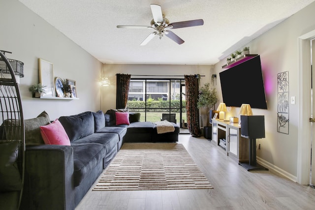 living room with a textured ceiling, light hardwood / wood-style floors, and ceiling fan