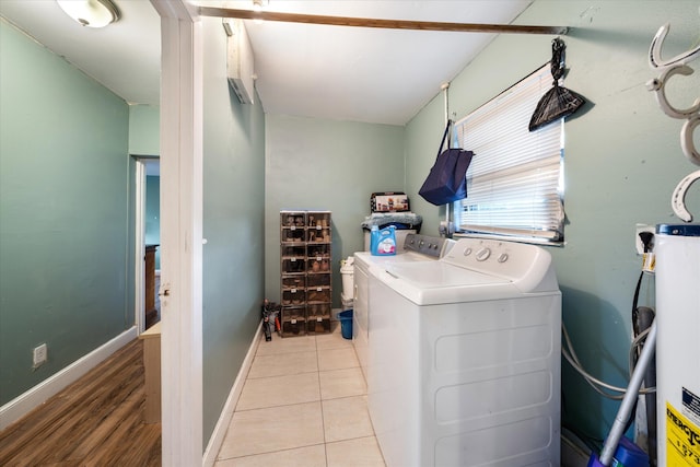 laundry area featuring light tile patterned flooring, gas water heater, and independent washer and dryer