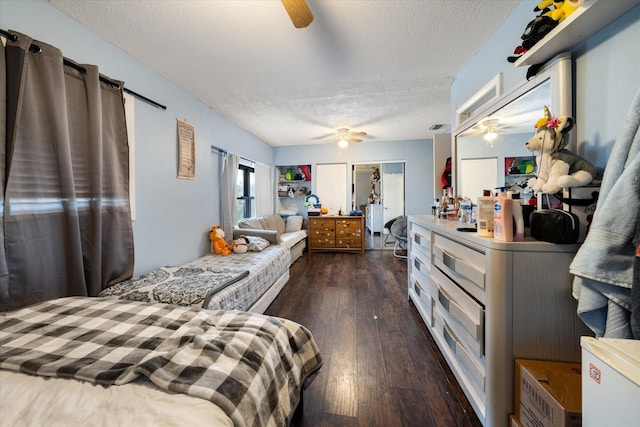 bedroom with a textured ceiling, dark hardwood / wood-style floors, and ceiling fan