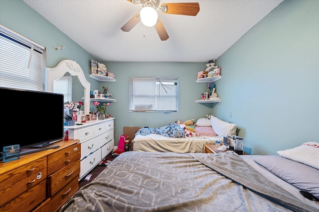 bedroom with ceiling fan and a textured ceiling