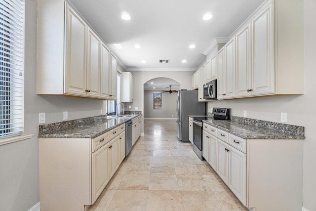 kitchen featuring ceiling fan, dark stone countertops, sink, and appliances with stainless steel finishes