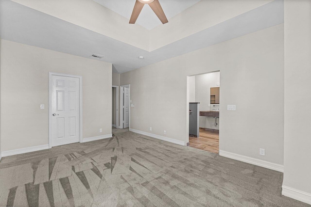 carpeted spare room featuring ceiling fan