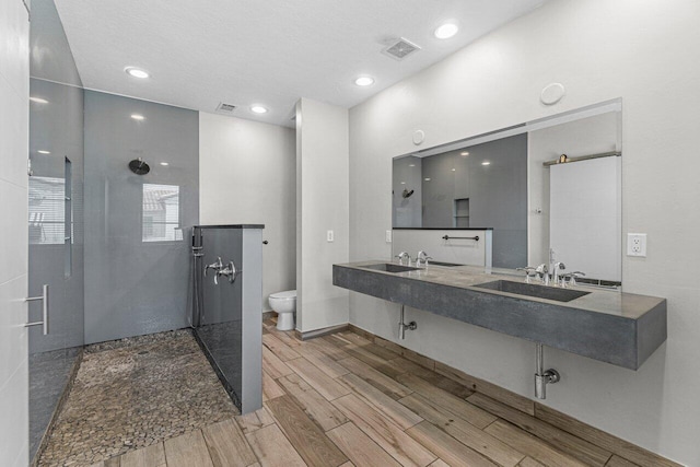 bathroom featuring hardwood / wood-style flooring, vanity, toilet, and walk in shower