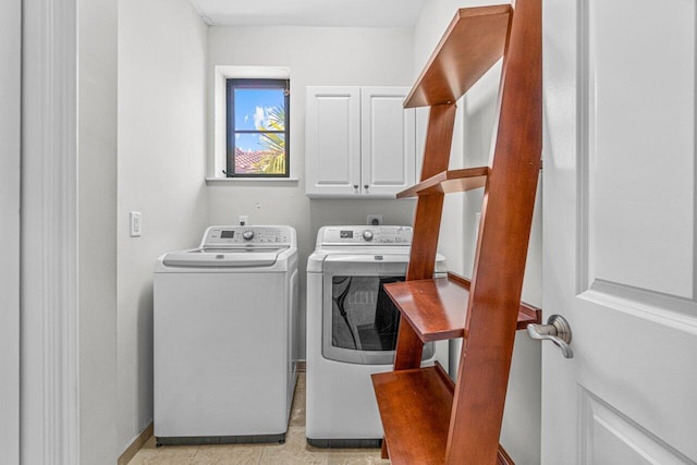 washroom featuring cabinets and washing machine and clothes dryer