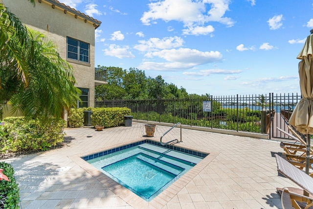 view of pool with a patio area, a community hot tub, and a water view